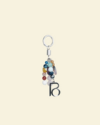 Keychain with colorful beads and a letter 'B' on a beige background